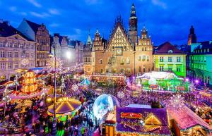 Un mercado navideño en una ciudad por la noche. en Plac Wolności 6 z klimatyzacją, en Poznan