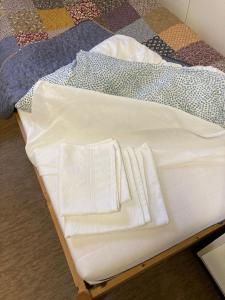 a bed with white sheets and towels on it at Guesthouse - Kuin Kotonaan in Kotka