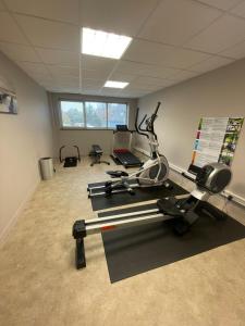 an office room with a gym with a treadmill at Hôtel Restaurant Bel Air Crevin - Axe Rennes Nantes in Crévin