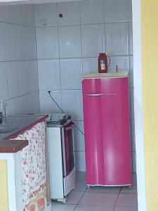 - un réfrigérateur rose dans une cuisine à côté d'une cuisinière dans l'établissement Apto vista p canal, à Cabo Frio