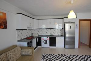a kitchen with white appliances and a couch in a room at GENI Apartment - Center Of Fethiye Close to the Beach Fast Wi-Fi Netflix in Fethiye