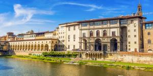 un edificio accanto a un fiume accanto a un ponte di UNYCA - Heart of Florence House a Firenze