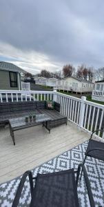 a deck with a couch and chairs on a porch at Sun sea and sand at Whitley bay caravan park in Whitley Bay