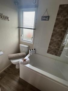 ウィットリー・ベイにある2 Bed Caravan - Sleeps 6 - Parking - Petsの浴槽、トイレ、窓のあるバスルーム