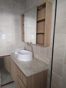 een badkamer met een wastafel en een spiegel bij Flat Palladium super aconchegante in São Vicente
