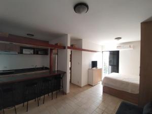 a bedroom with a bed and a kitchen with a sink at Flat Palladium super aconchegante in São Vicente