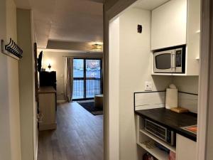 eine Küche mit einer Mikrowelle und eine Tür zu einem Zimmer in der Unterkunft Park City Southwestern Bunker in Park City