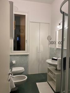 ein weißes Bad mit einem WC und einem Waschbecken in der Unterkunft Casa Giulietta in Cremona