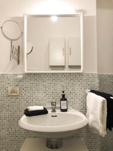 ein Badezimmer mit einem weißen Waschbecken und einem Spiegel in der Unterkunft Casa Giulietta in Cremona