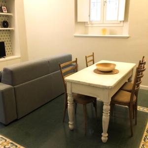 ein Wohnzimmer mit einem Tisch und einem Sofa in der Unterkunft Casa Giulietta in Cremona