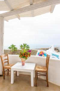 a table and two chairs and a vase with flowers at Paradise Beach Resort in Paradise Beach