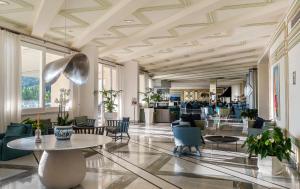 a lobby with a table and chairs and windows at Grand Hotel Vesuvio in Sorrento