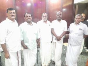 a group of men in white uniforms posing for a picture at Urban Rose Homestay in Kannur