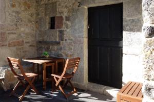 a table and two chairs in front of a door at Belenos Alojamientos Turísticos in Niembro