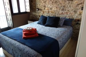 a bedroom with a bed with a red bag on it at Belenos Alojamientos Turísticos in Niembro