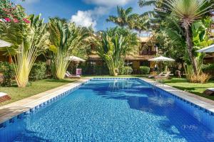 a swimming pool in front of a house with palm trees at Linda Casa no Pipa Beleza in Pipa