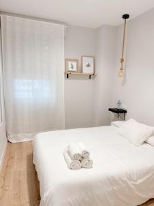 a bedroom with a white bed with towels on it at CENTER FLAT MEZQUITA in Córdoba