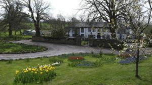 a garden in front of a house with flowers at Rowrah Hall - The Old Dairy in Rowrah