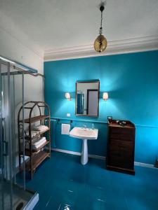 a blue bathroom with a sink and a mirror at La Stazione di Posta in Cassino