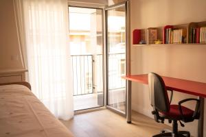 Schlafzimmer mit einem Schreibtisch, einem Stuhl und einem Fenster in der Unterkunft Apartamento NUEVO en el centro de LEON in León