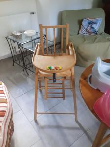 a wooden chair sitting in a room with a table at L'Ancienne Colonie - maison conviviale au bord de la Gazeille - 8 pers in Le Monastier sur Gazeille