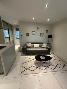 a living room with a couch and a rug at Maison d'hôtes chic à Beauzelle in Beauzelle