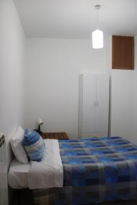 Un dormitorio con una cama con una manta azul. en La collina degli ulivi, en Conocchia