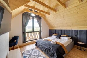 - une chambre avec un lit et une grande fenêtre dans l'établissement Rezydencja Widok, à Kluszkowce