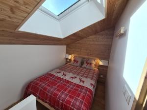 um pequeno quarto com uma cama num sótão em CMD Méribel em Méribel