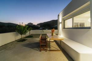 a balcony with a wooden table and a window at Nikkon summer house in Matala
