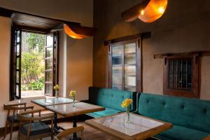 ein Restaurant mit zwei Tischen und einer grünen Couch in der Unterkunft Hotel Ibarra 14 in Pátzcuaro