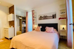 - une chambre avec un grand lit et des oreillers roses dans l'établissement Saint-Maurice face au bois de Vincennes, à Saint-Maurice