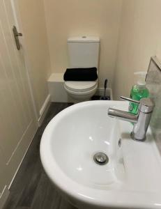 a bathroom with a white sink and a toilet at Ensuite Room, Hotel Standard. Close to Crewe Train Station in Crewe