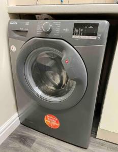a gray washing machine with its door open at Ensuite Room, Hotel Standard. Close to Crewe Train Station in Crewe