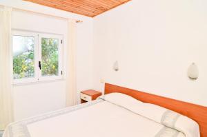 a white bedroom with a bed and a window at Residence Limoneto Ischia in Ischia