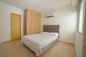 um quarto com uma cama e um armário de madeira em Casa Hotel Jardín Plaza em Santa Marta
