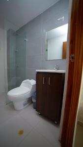 ein Badezimmer mit einem WC, einem Waschbecken und einem Spiegel in der Unterkunft Casa Hotel Jardín Plaza in Santa Marta