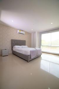 1 dormitorio con cama grande y ventana grande en Casa Hotel Jardín Plaza en Santa Marta