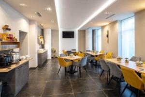 uma sala de jantar com mesas e cadeiras amarelas em Inter Hotel em Debrecen