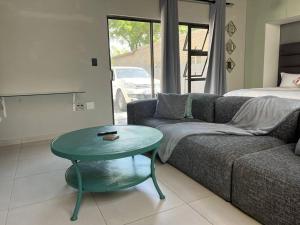 uma sala de estar com um sofá e uma mesa em 31 on Forest (Matamela Suite) em Joanesburgo