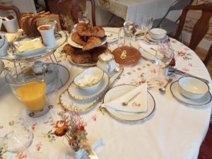 un tavolo con una tovaglia bianca con sopra del cibo di MAISON GAY LUSSAC St LEONARD DE NOBLAT a Saint-Léonard-de-Noblat
