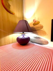 um candeeiro roxo sentado em cima de uma cama em Rhome86 em Roma