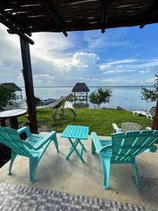 3 sedie e un tavolo da picnic con vista sull'oceano di Luigi’s Glamping a Bacalar