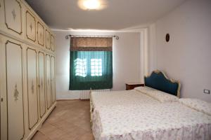 een slaapkamer met een bed en een groen raam bij agriturismo villaggio green in Montefalco
