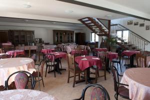 モンテファルコにあるagriturismo villaggio greenのピンクのテーブルクロスを使用したテーブルと椅子付きのレストランを併設しています。