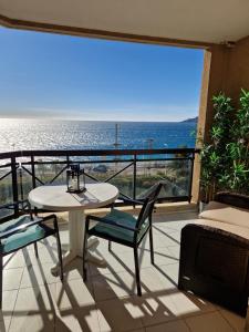 uma varanda com mesa e cadeiras e vista para o oceano em VILLA MAUPASSANT BORD DE MER em Cannes