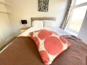 a bedroom with a bed with a red and white blanket at Budget Room Share facilities R3 in Swansea +4 photos