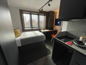 ein kleines Zimmer mit einem kleinen Bett und einem Fenster in der Unterkunft Lovely 1 Bed Studio (3B) near Royal Infirmary and DMU in Leicester