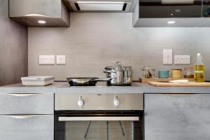 a kitchen with a sink and a stove top oven at The Owl Barn Wiltshire - Sarsen in Swindon +8 photos
