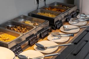 a buffet with plates and utensils on a table at Inter Hotel in Debrecen
